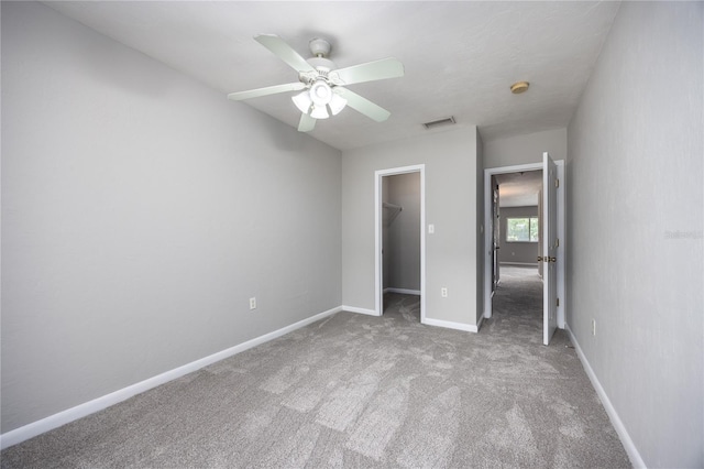 501 SW 75th St Unit E3, Gainesville, FL 32607 - unfurnished bedroom with a walk in closet, carpet flooring, a closet, a ceiling fan, and baseboards