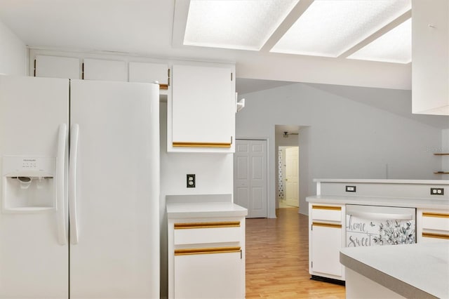 kitchen featuring white cabinetry, white refrigerator with ice dispenser, light countertops, and light wood finished floors