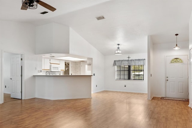 unfurnished living room with light wood-type flooring, a ceiling fan, baseboards, and visible vents