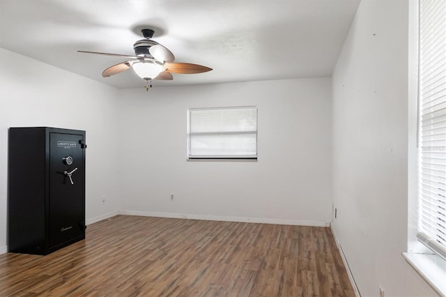 spare room with baseboards, wood finished floors, and ceiling fan