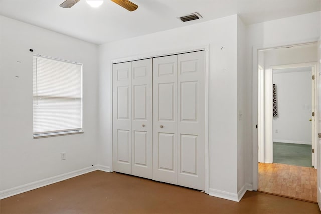 unfurnished bedroom with baseboards, ceiling fan, visible vents, a closet, and wood finished floors