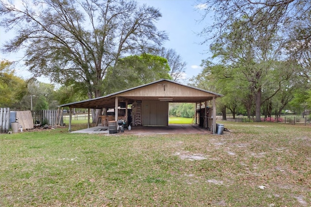 view of pole building featuring a lawn and fence