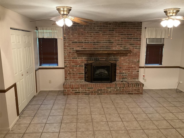 unfurnished living room featuring light tile patterned floors, baseboards, a fireplace, and ceiling fan