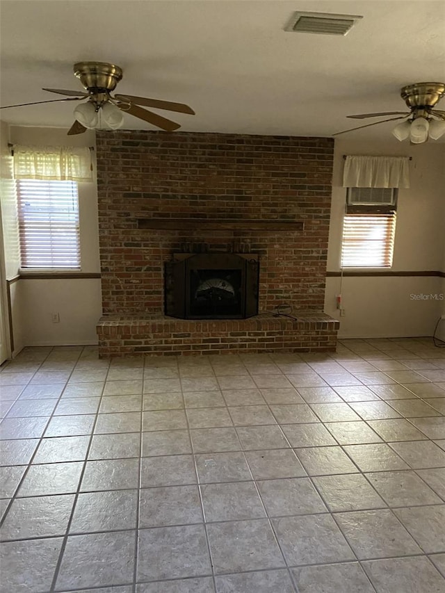 unfurnished living room with a ceiling fan, a wealth of natural light, light tile patterned floors, and visible vents