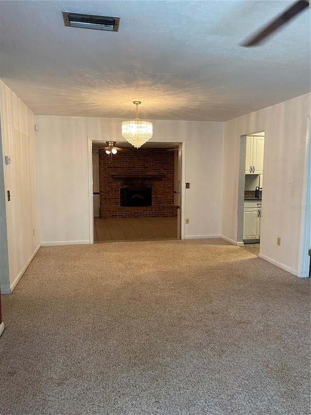 interior space featuring a fireplace, carpet floors, visible vents, baseboards, and a chandelier