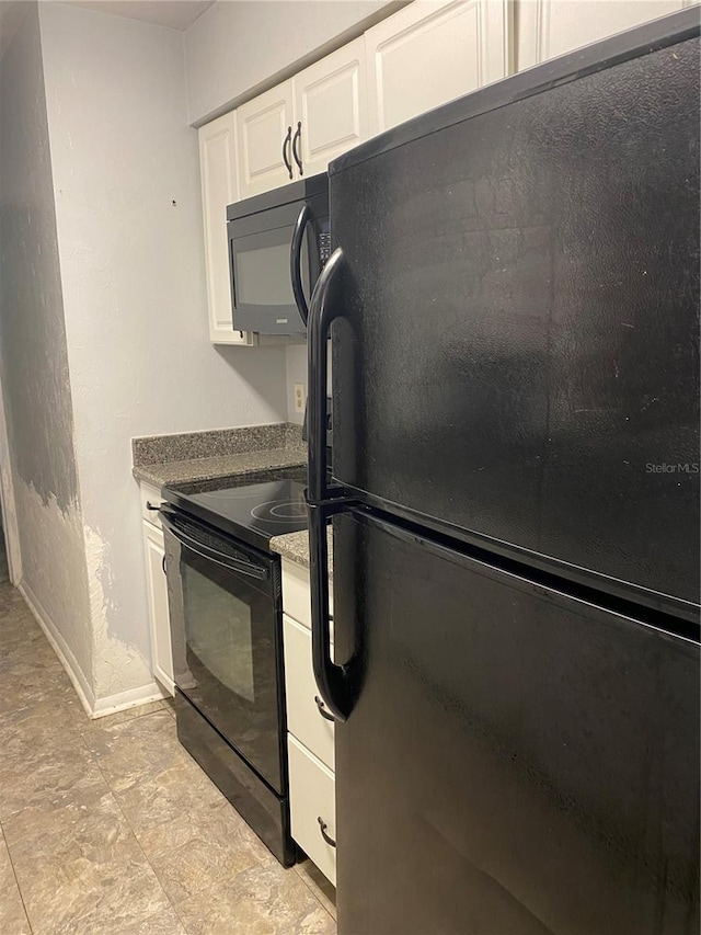 kitchen with white cabinets, baseboards, and black appliances