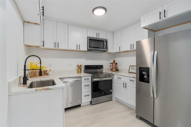 4120 NW 10th St, Gainesville, FL 32609 - kitchen featuring appliances with stainless steel finishes, a sink, white cabinetry, and light countertops