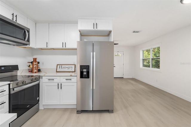 4120 NW 10th St, Gainesville, FL 32609 - kitchen with appliances with stainless steel finishes, light wood-style flooring, light countertops, white cabinetry, and baseboards
