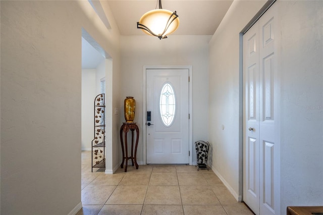 entryway with baseboards and light tile patterned floors