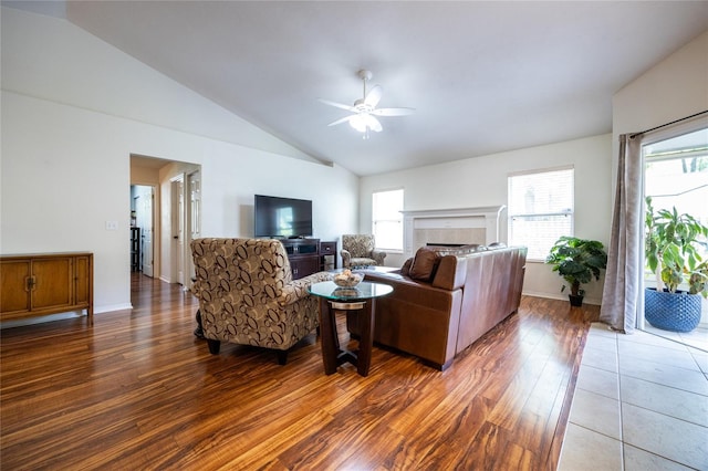 living room featuring ceiling fan, vaulted ceiling, a wealth of natural light, and wood finished floors