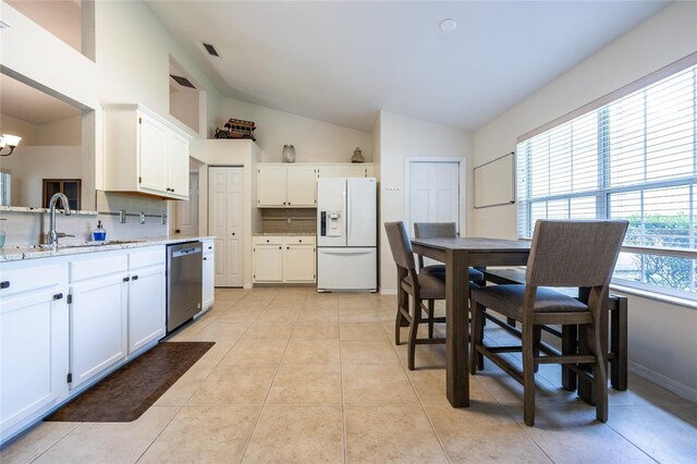 kitchen featuring stainless steel dishwasher, white cabinetry, a sink, vaulted ceiling, and white fridge with ice dispenser
