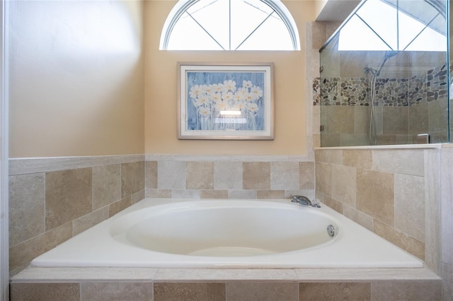 bathroom featuring a garden tub and tiled shower