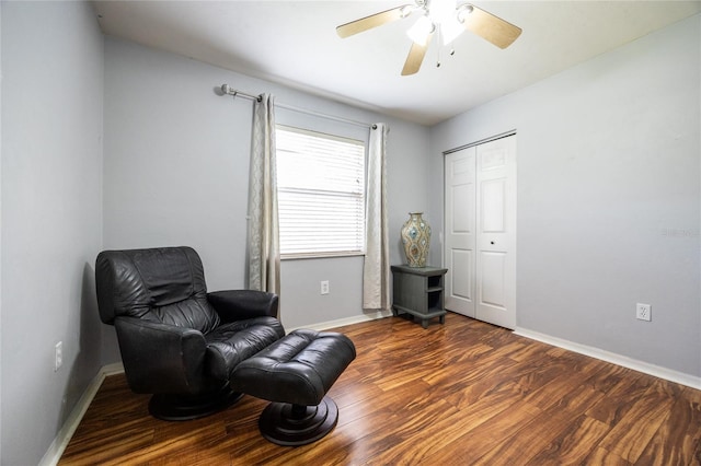 living area with a ceiling fan, baseboards, and wood finished floors