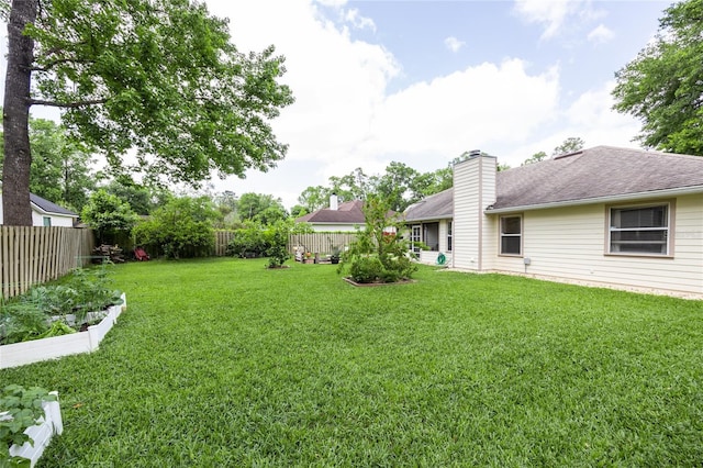 view of yard featuring a fenced backyard and a vegetable garden
