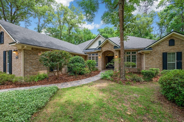 4535 SW 105th Dr, Gainesville, FL 32608 - view of front of house with brick siding, a shingled roof, and a front yard
