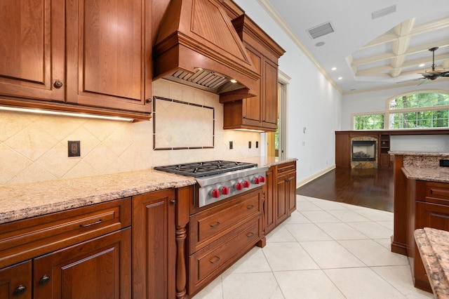 4535 SW 105th Dr, Gainesville, FL 32608 - kitchen with custom exhaust hood, stainless steel gas stovetop, coffered ceiling, light stone counters, and ceiling fan