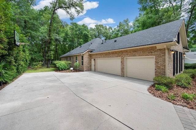 4535 SW 105th Dr, Gainesville, FL 32608 - view of property exterior with brick siding, roof with shingles, concrete driveway, and a garage