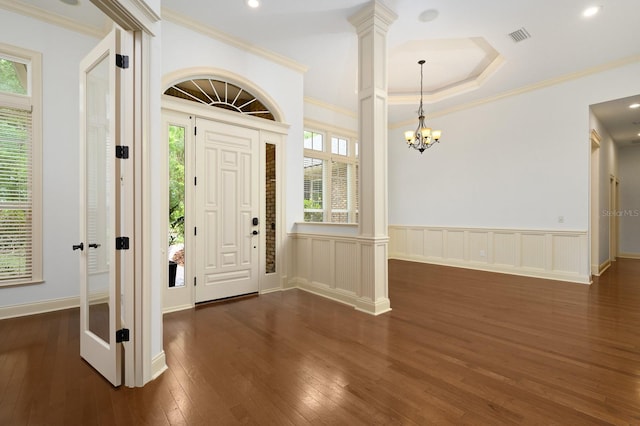 4535 SW 105th Dr, Gainesville, FL 32608 - foyer with dark wood-type flooring, ornate columns, wainscoting, crown molding, and a chandelier