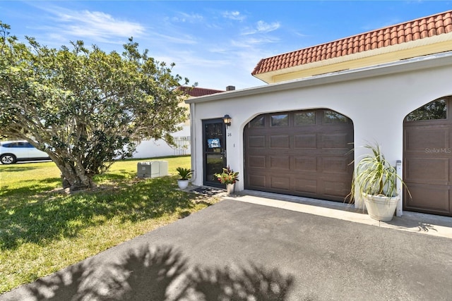 26 Ocean Palm Villa S Unit 26, Flagler Beach, FL 32136 - exterior space featuring a tiled roof, a garage, aphalt driveway, a front lawn, and stucco siding