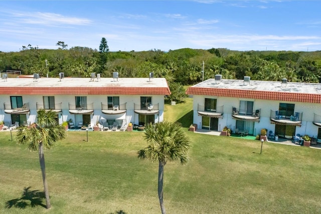 26 Ocean Palm Villa S Unit 26, Flagler Beach, FL 32136 - rear view of property featuring a tiled roof, a yard, and a wooded view