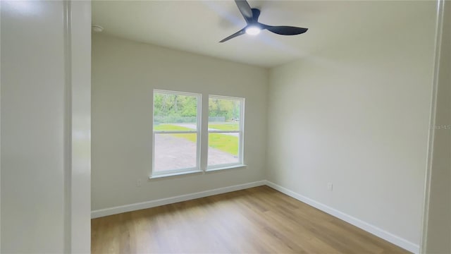 empty room featuring baseboards, light wood-style floors, and a ceiling fan