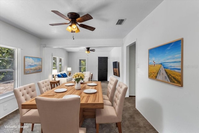 carpeted dining space with a ceiling fan and visible vents