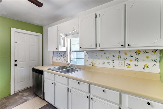 kitchen with stainless steel dishwasher, white cabinets, light countertops, and a sink