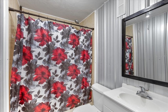 bathroom with a shower with curtain, toilet, and vanity