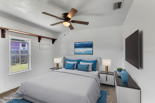 carpeted bedroom featuring visible vents and a ceiling fan