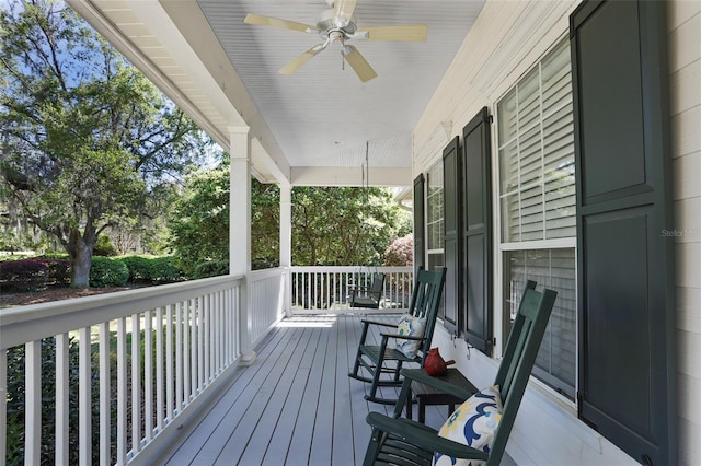 wooden terrace featuring covered porch and a ceiling fan