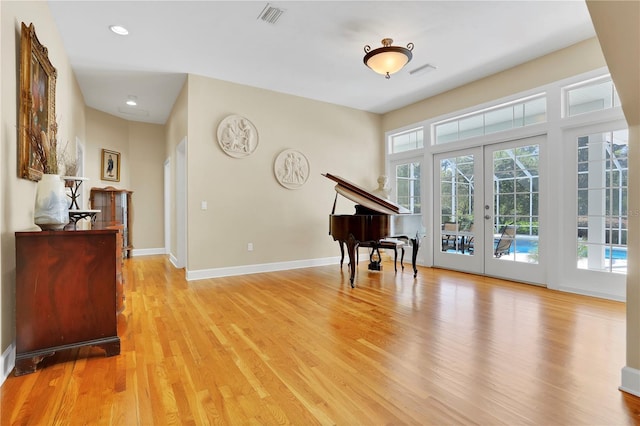 sitting room with light wood-style flooring, visible vents, baseboards, recessed lighting, and french doors