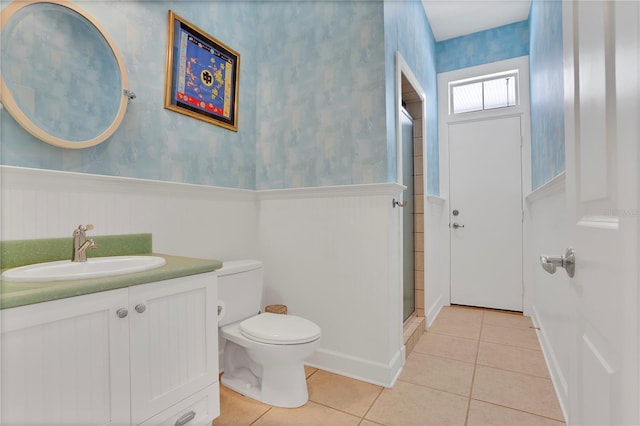 full bath featuring a wainscoted wall, toilet, tile patterned floors, and wallpapered walls
