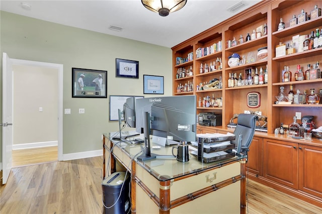 office with baseboards, visible vents, and light wood-style floors