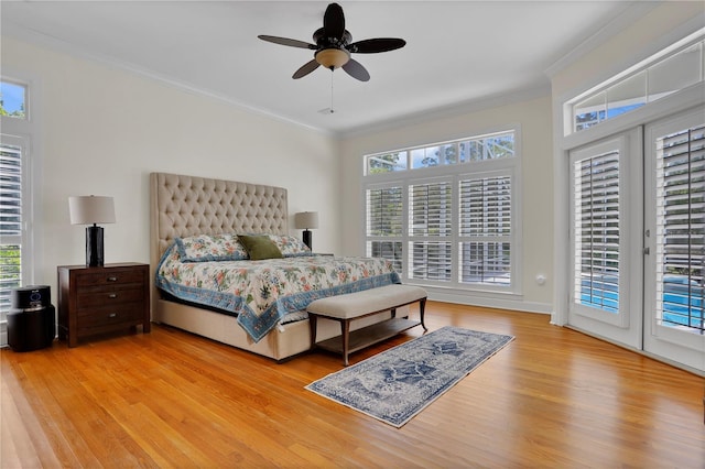 bedroom with multiple windows, access to exterior, crown molding, and wood finished floors