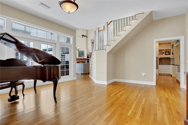 interior space with baseboards, stairs, and light wood finished floors