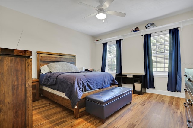 bedroom with baseboards, light wood-style floors, and ceiling fan