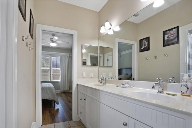 bathroom with double vanity, connected bathroom, a sink, and a ceiling fan
