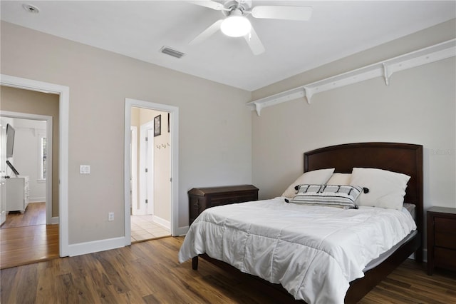 bedroom with baseboards, ceiling fan, visible vents, and wood finished floors