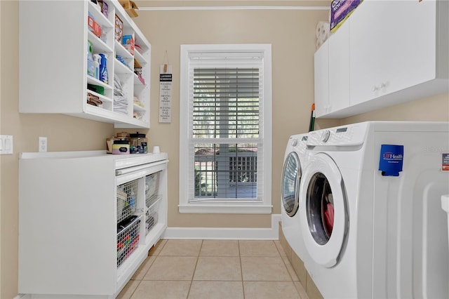 clothes washing area featuring light tile patterned flooring, cabinet space, independent washer and dryer, and baseboards