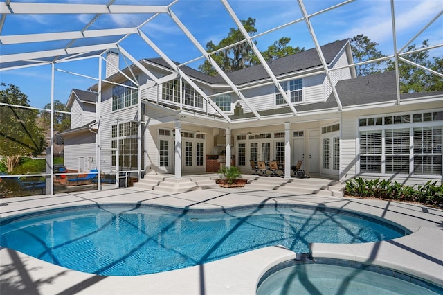 view of pool with french doors, entry steps, glass enclosure, a pool with connected hot tub, and a patio area