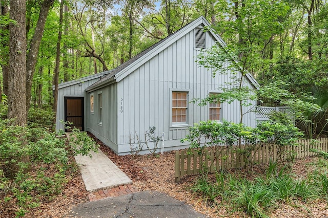 view of property exterior with board and batten siding and fence