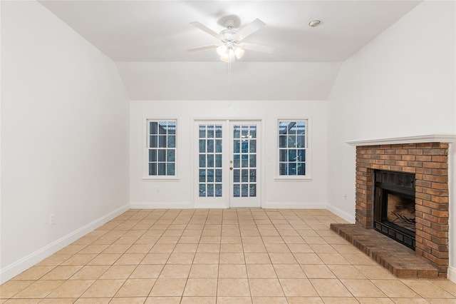 unfurnished living room featuring french doors, ceiling fan, a brick fireplace, vaulted ceiling, and baseboards