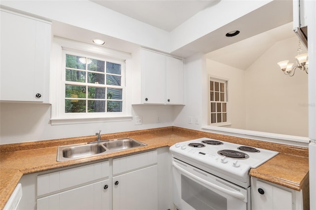 kitchen with white appliances, a sink, white cabinetry, light countertops, and a peninsula