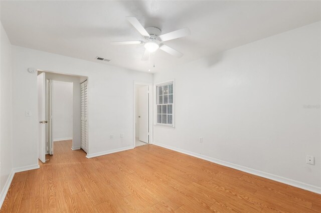 unfurnished bedroom with light wood-type flooring, baseboards, a closet, and a ceiling fan