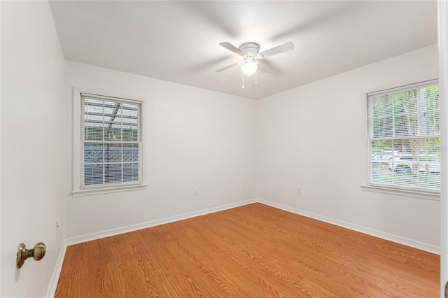 empty room with a ceiling fan, baseboards, and light wood finished floors