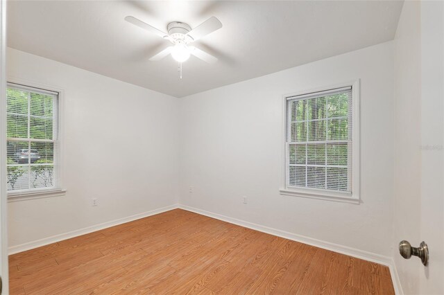 empty room with light wood-type flooring, baseboards, and a ceiling fan