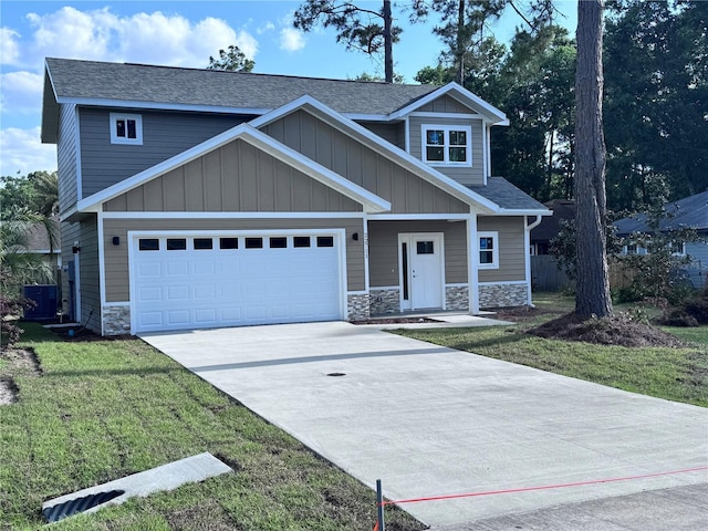craftsman inspired home featuring a front lawn, a shingled roof, stone siding, central AC, and concrete driveway