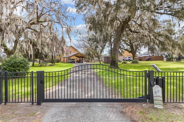 view of gate with a lawn and fence