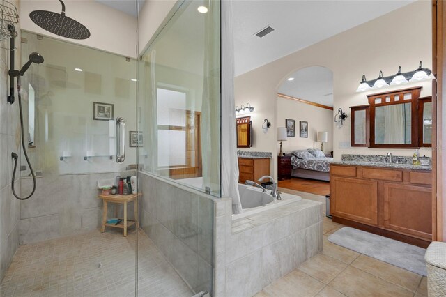 full bath featuring connected bathroom, a tile shower, vanity, tile patterned flooring, and visible vents