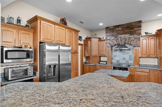 kitchen featuring a toaster, backsplash, light stone counters, visible vents, and appliances with stainless steel finishes